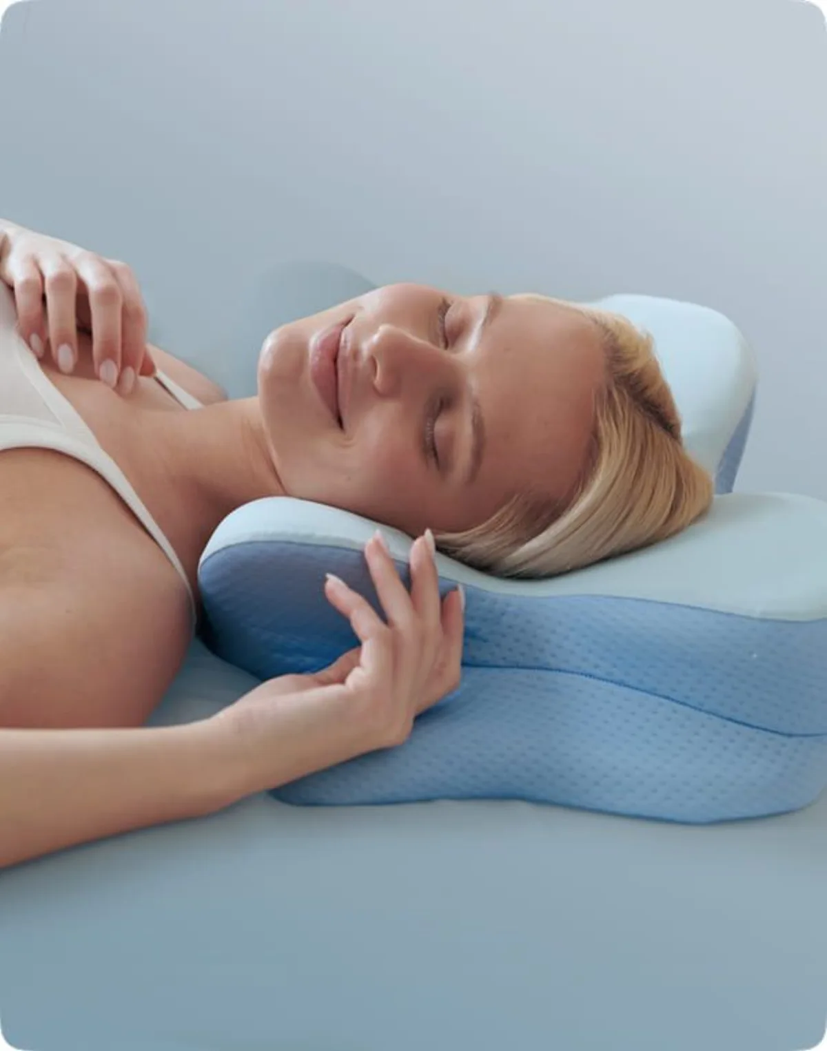 Woman resting on Derila Ergo pillow showing relaxed shoulder and neck position