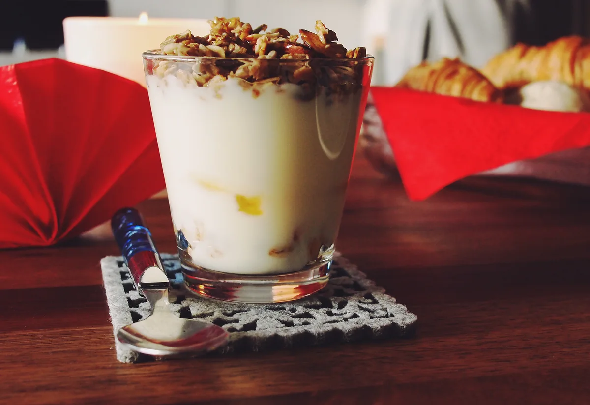 Glass of yogurt with granola on a wooden table