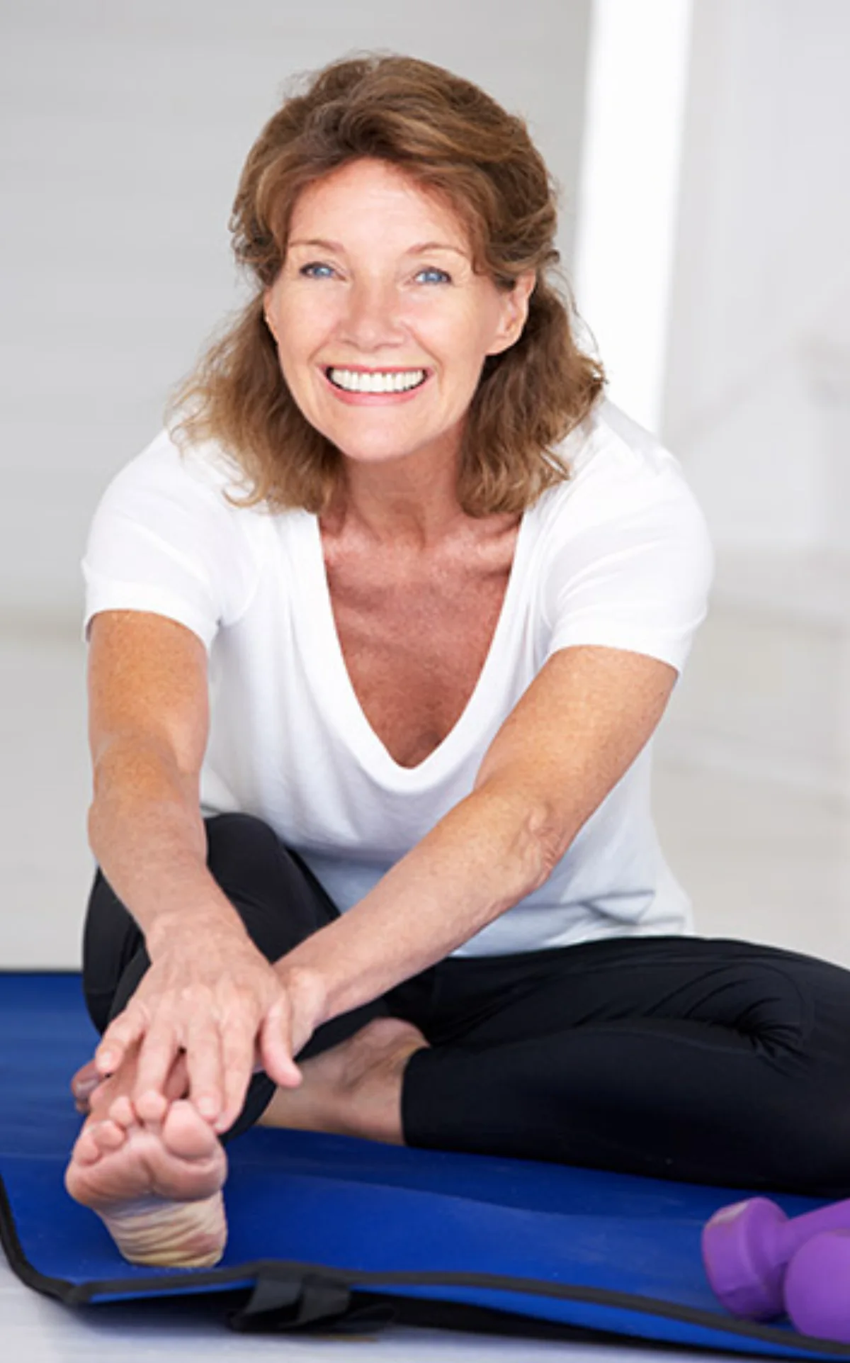 Active woman in her 50s stretching on a yoga mat with good joint mobility