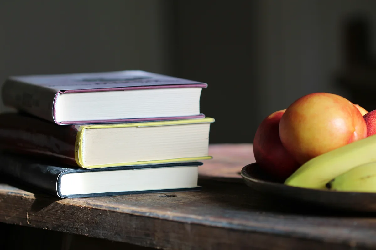 Various dietary pattern books and food plates representing different nutrition philosophies